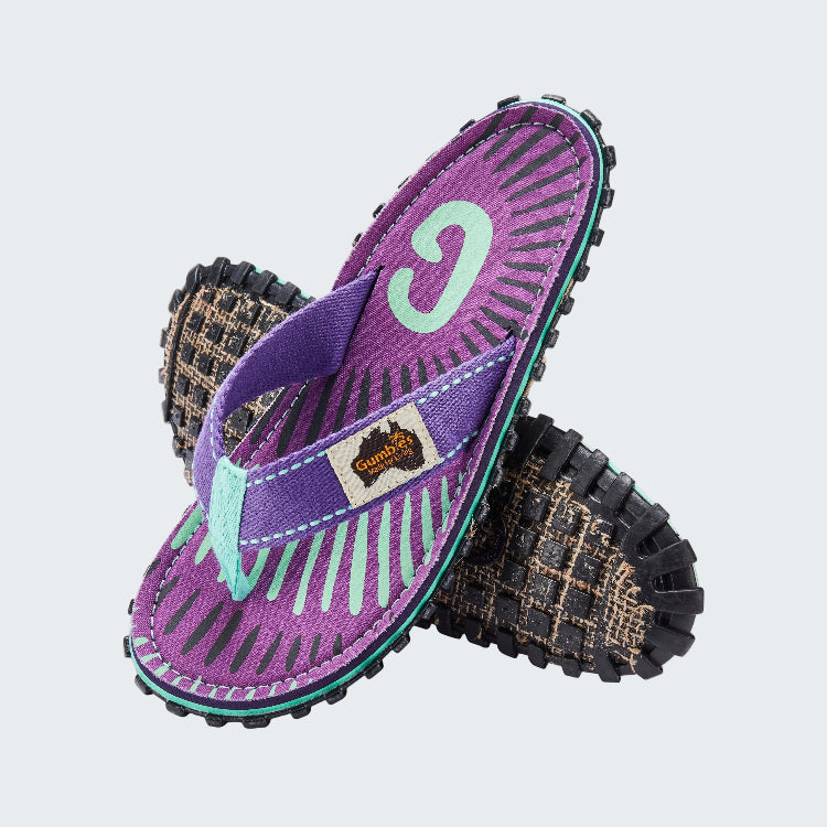 Purple and black sandals with a visible brand logo on a white background
