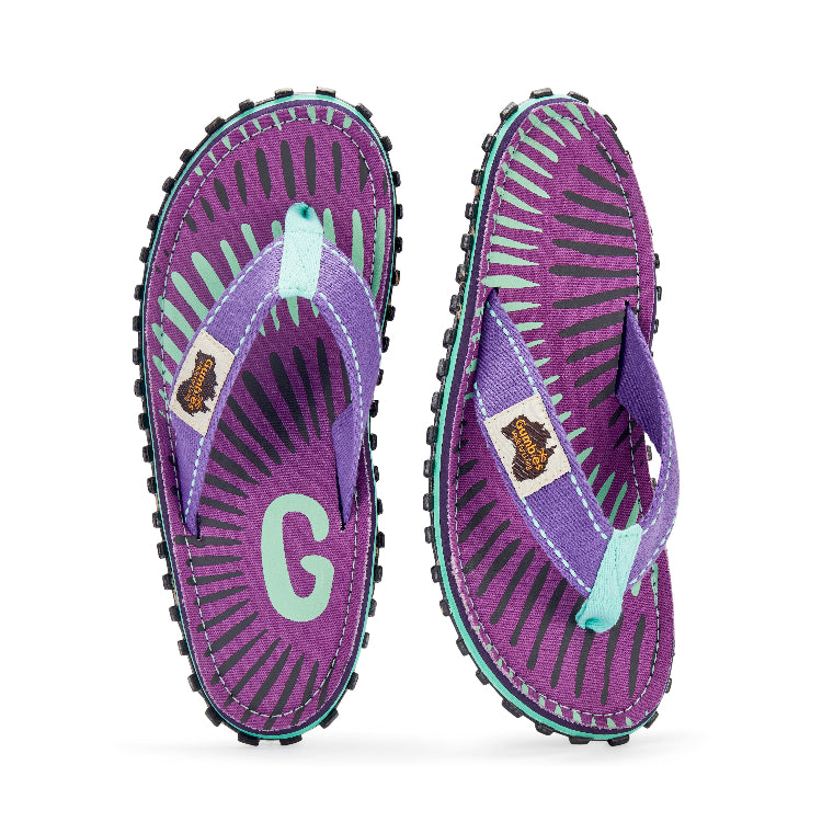 Purple flip-flops with a 'G' logo on a white background