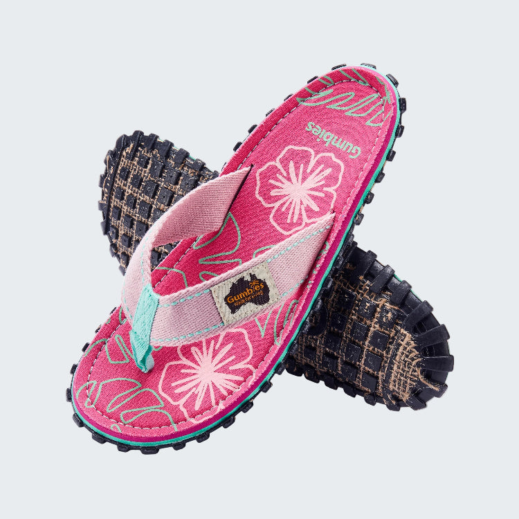 Pink sandals with floral design and textured sole on a white background
