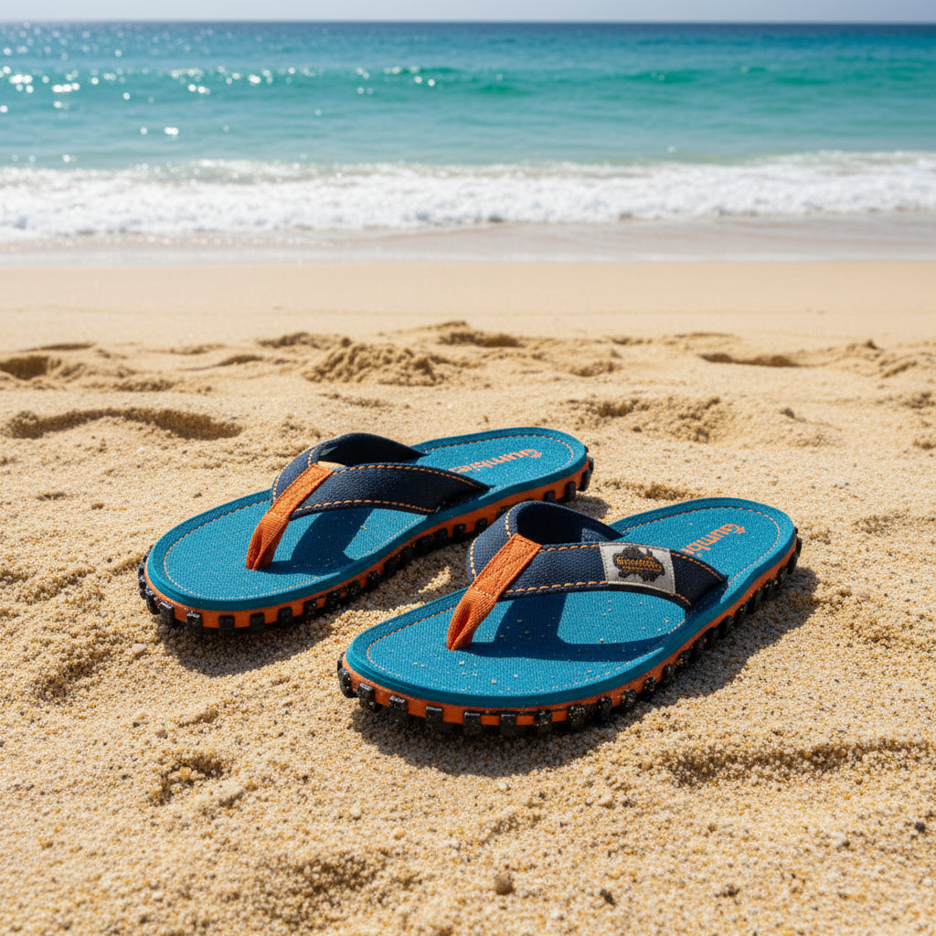 Pair of blue sandals with orange straps on a white background