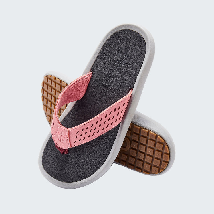 Pair of flip-flops with pink straps and brown waffle sole on a white background