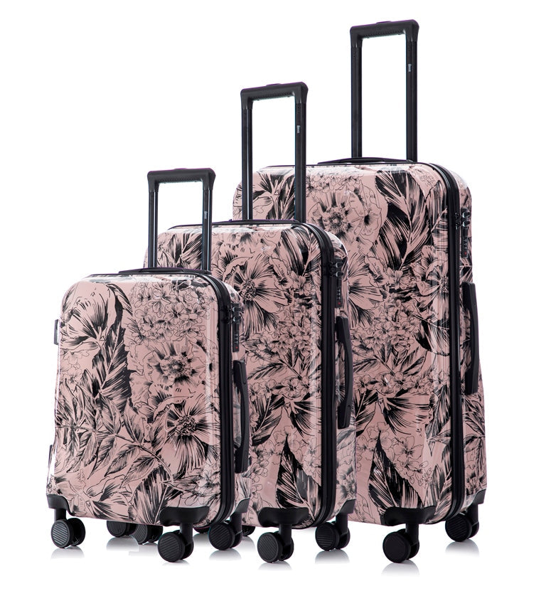 Set of three floral-patterned suitcases on a white background