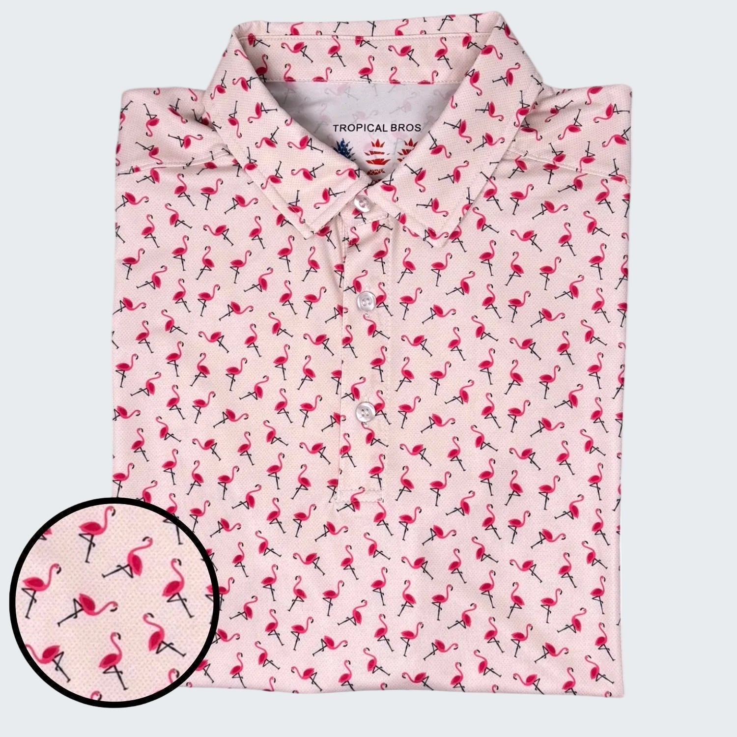 Folded pink shirt with flamingo pattern on a white background