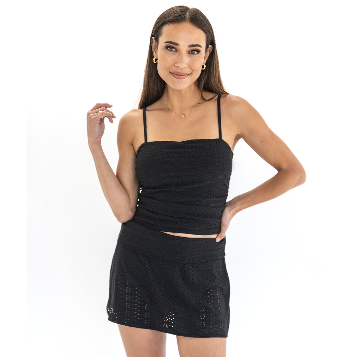 Woman wearing a black top and skirt on a white background