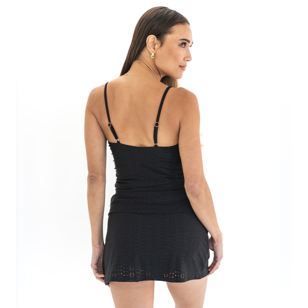 Woman wearing a black dress with thin straps on a white background