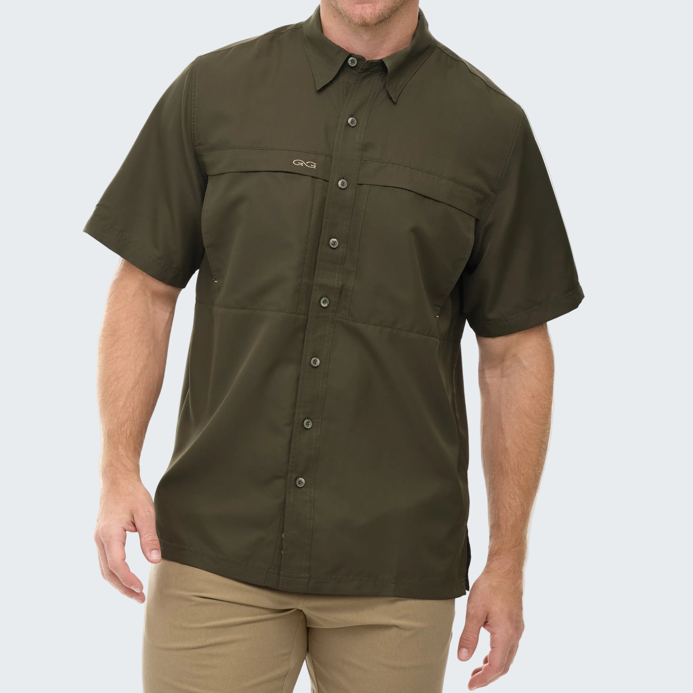 Man wearing a green short-sleeve shirt with button details on a white background