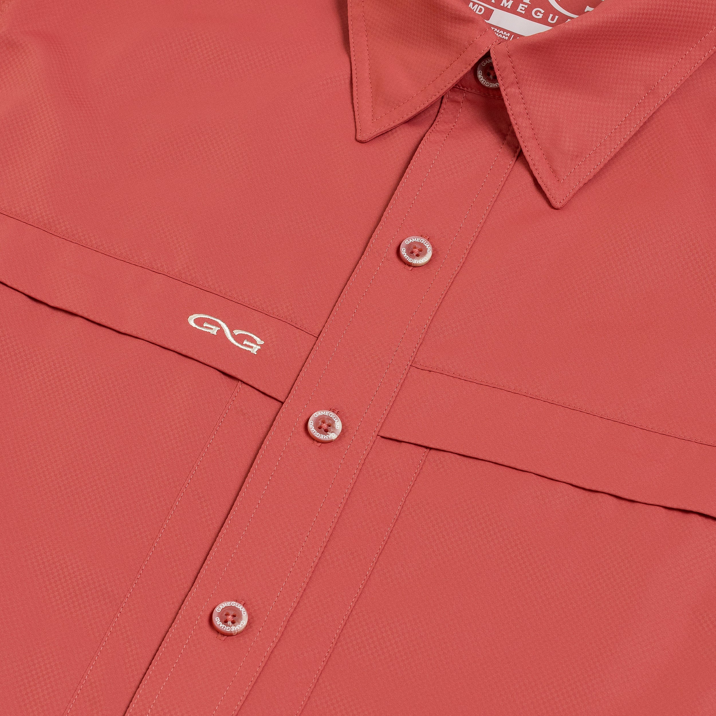 Close-up of a red shirt with a brand logo on a plain background