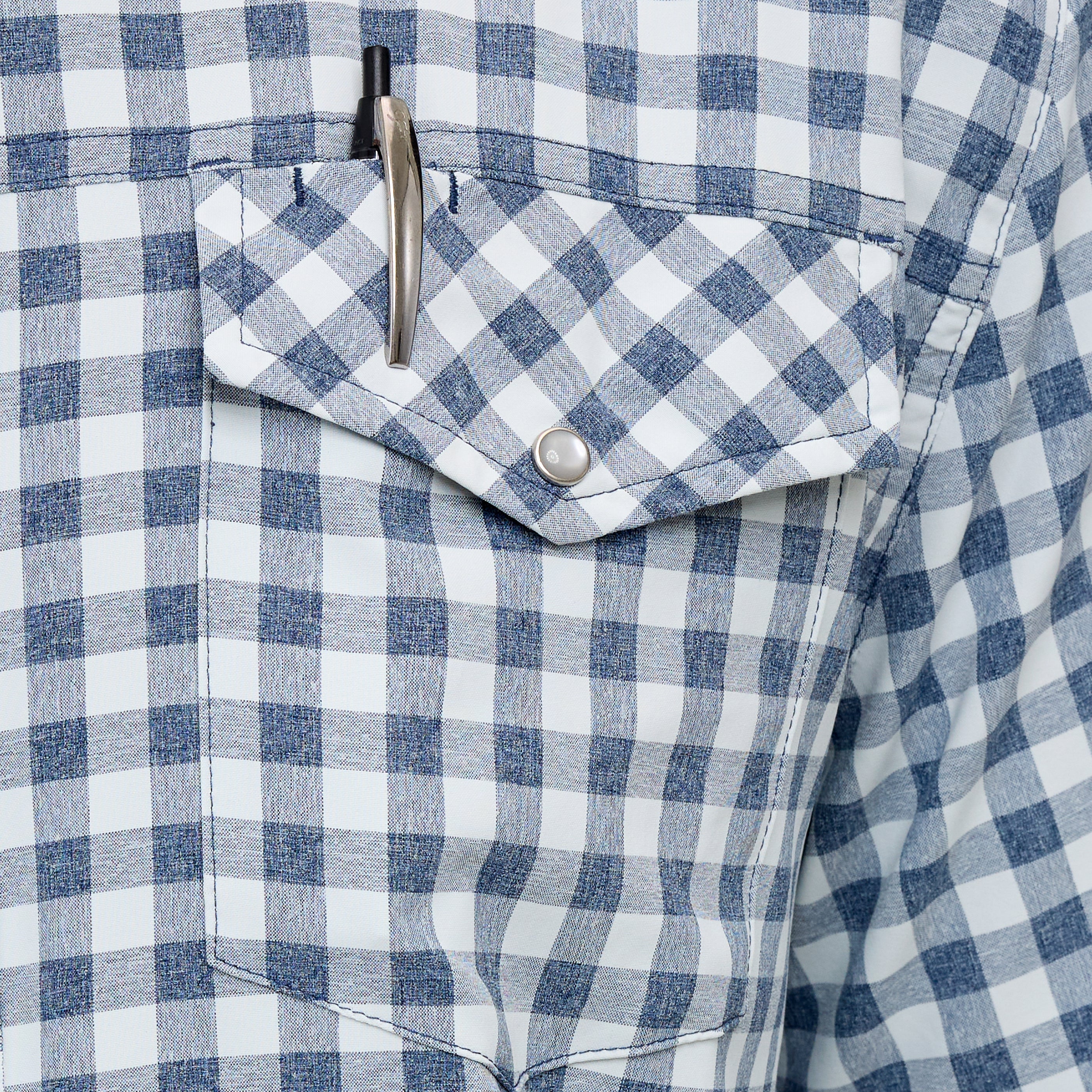Close-up of a blue and white checkered shirt with a pen in the pocket.