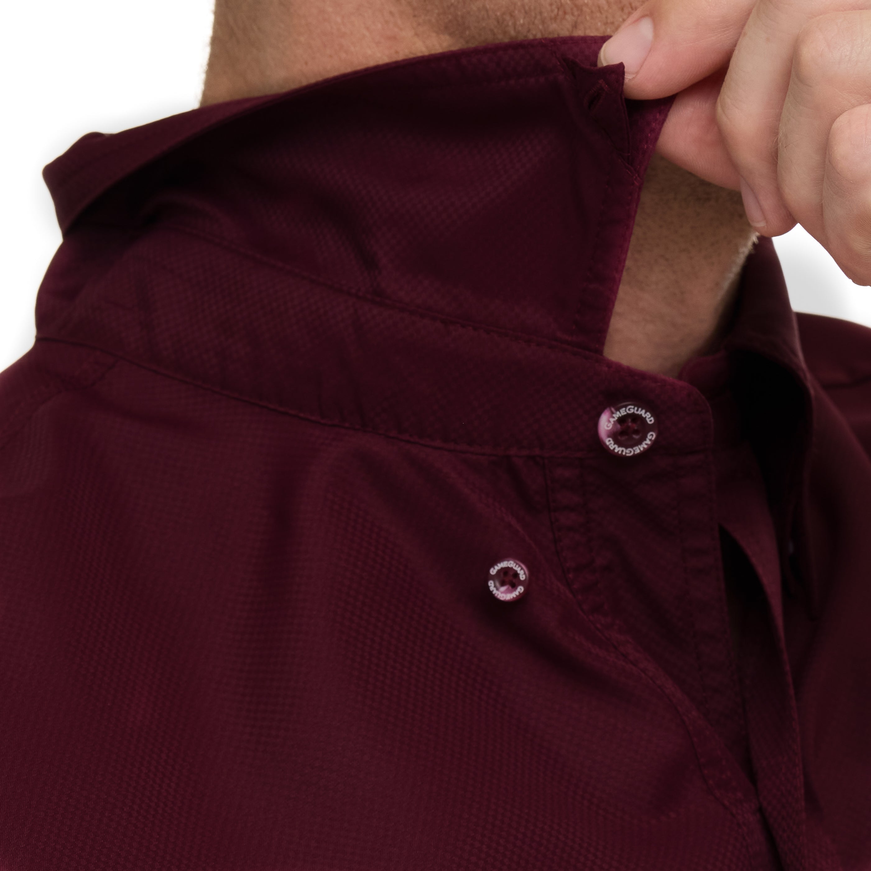 Close-up of a person adjusting the hood of a maroon jacket.