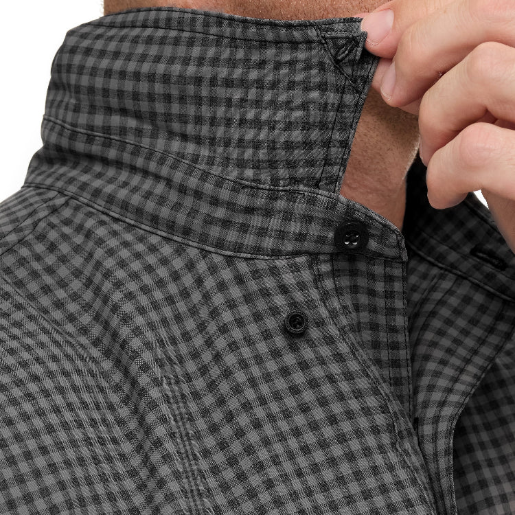 Close-up of a person wearing a black and gray checkered jacket with a buttoned collar.