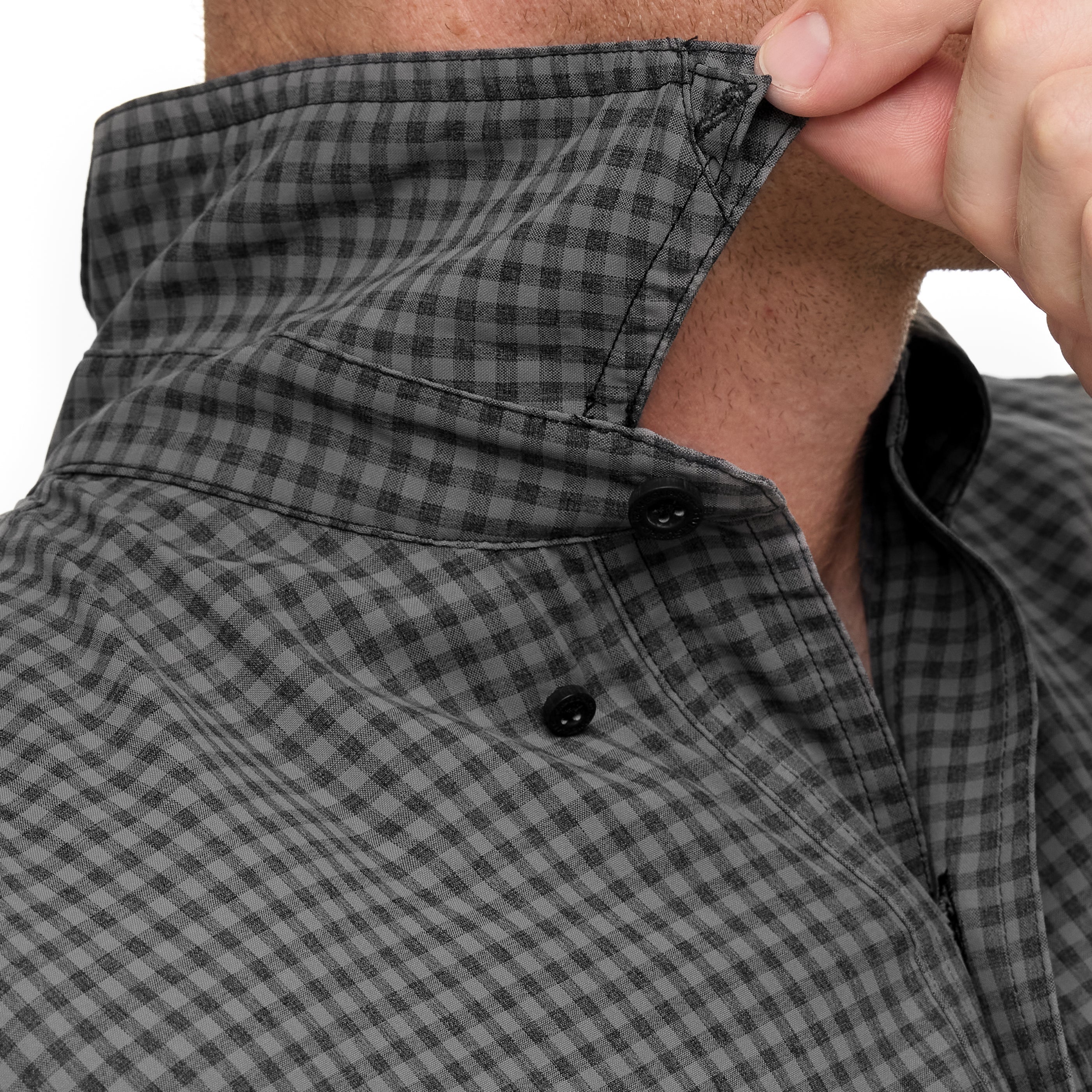 Close-up of a person wearing a gray checkered shirt with a focus on the collar and buttons.