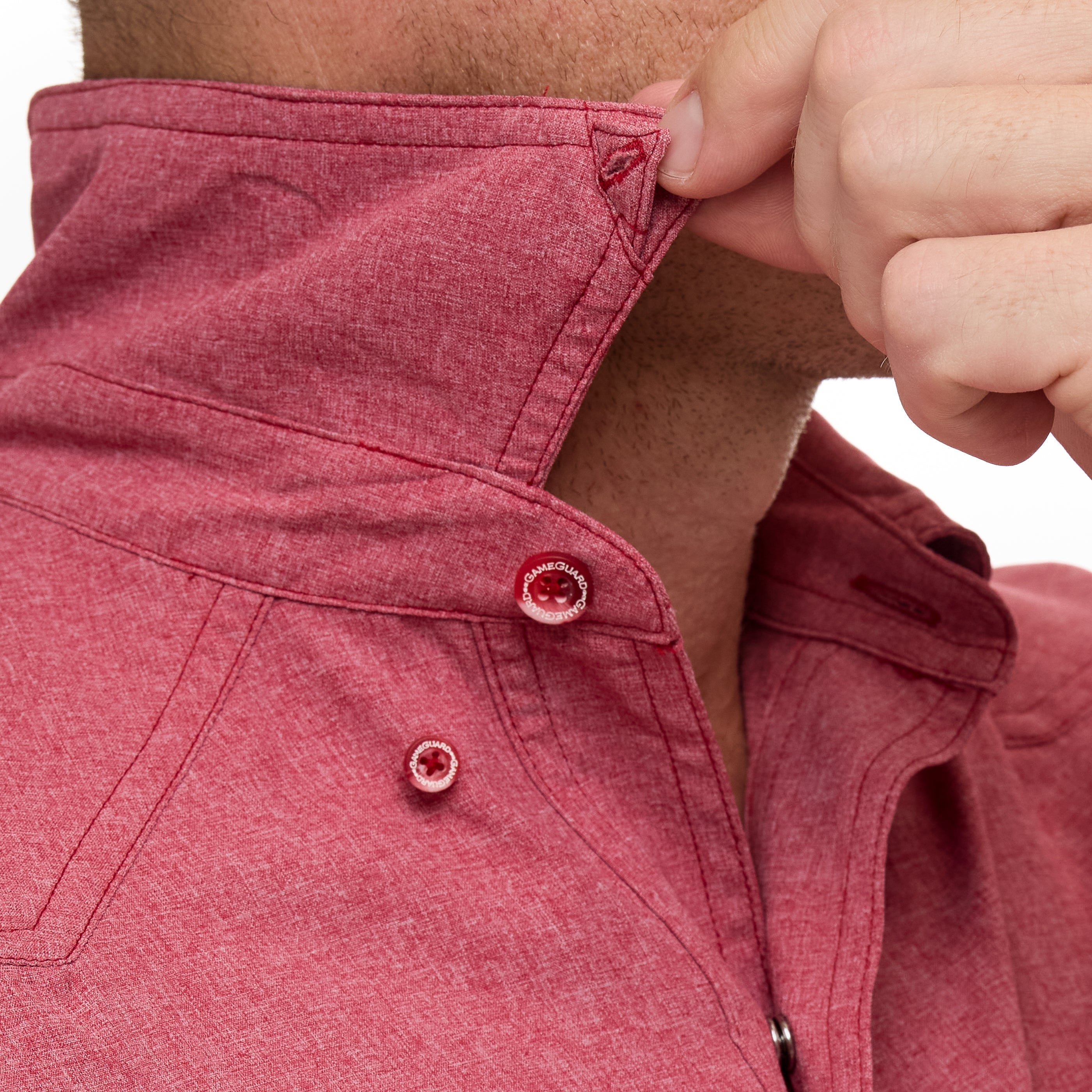 Close-up of a person adjusting the collar of a red jacket.