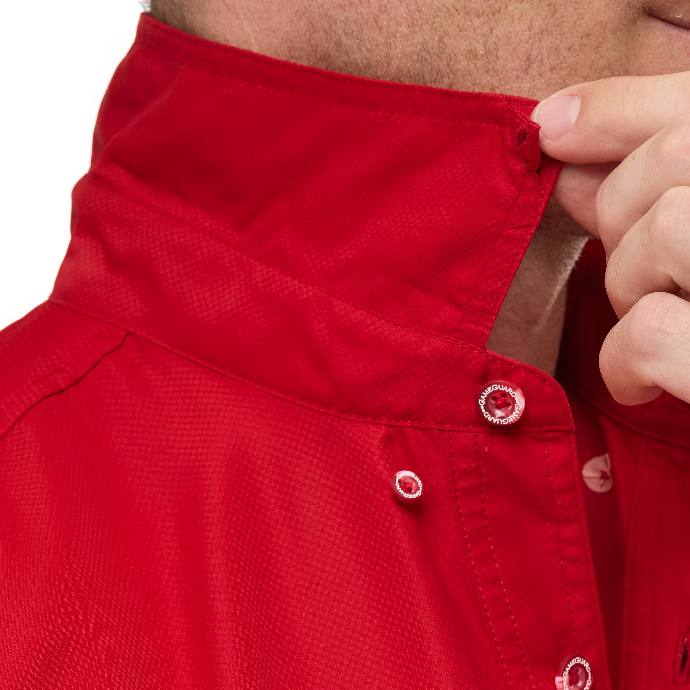 Close-up of a red shirt with buttons being adjusted by a hand.