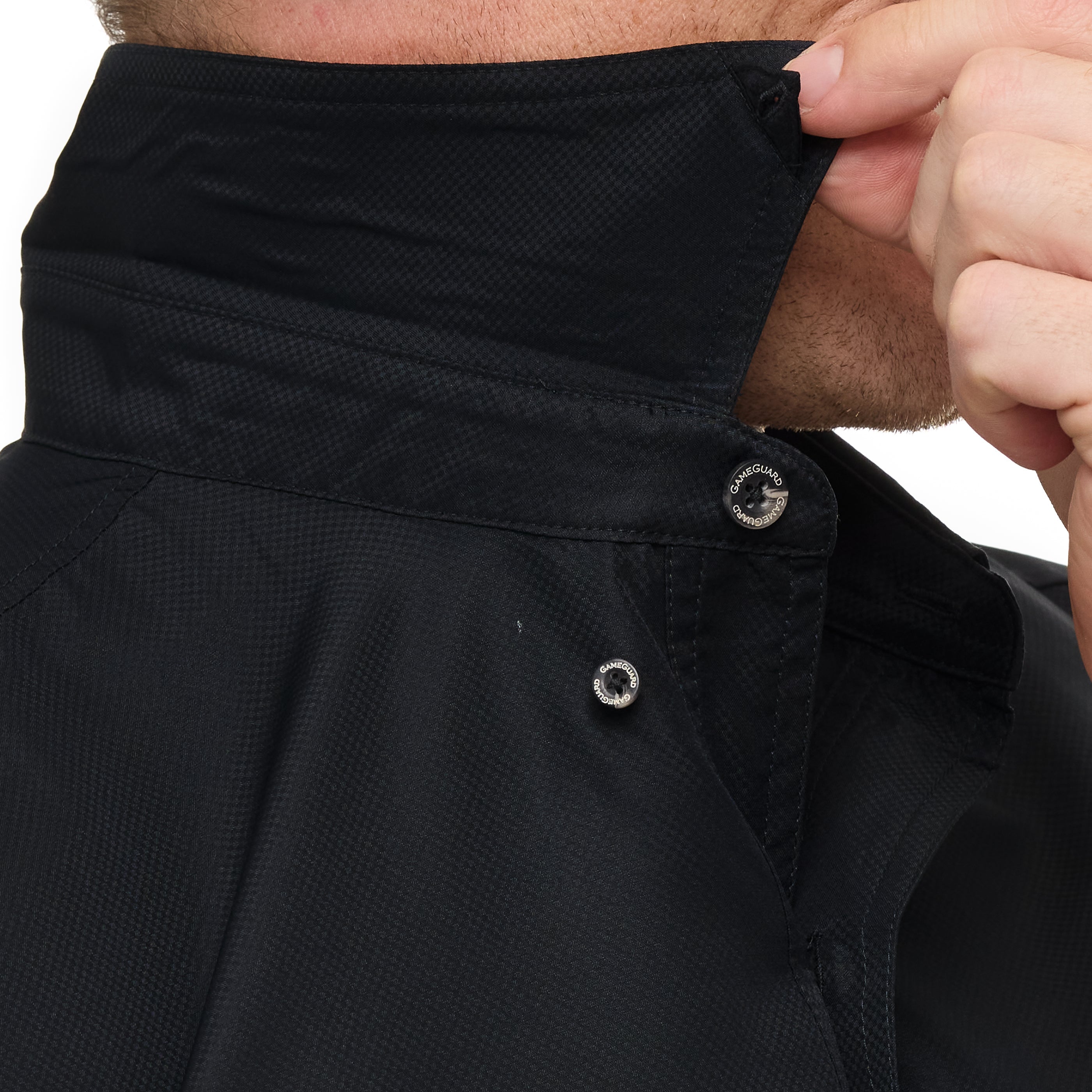 Close-up of a person adjusting the collar of a black jacket.