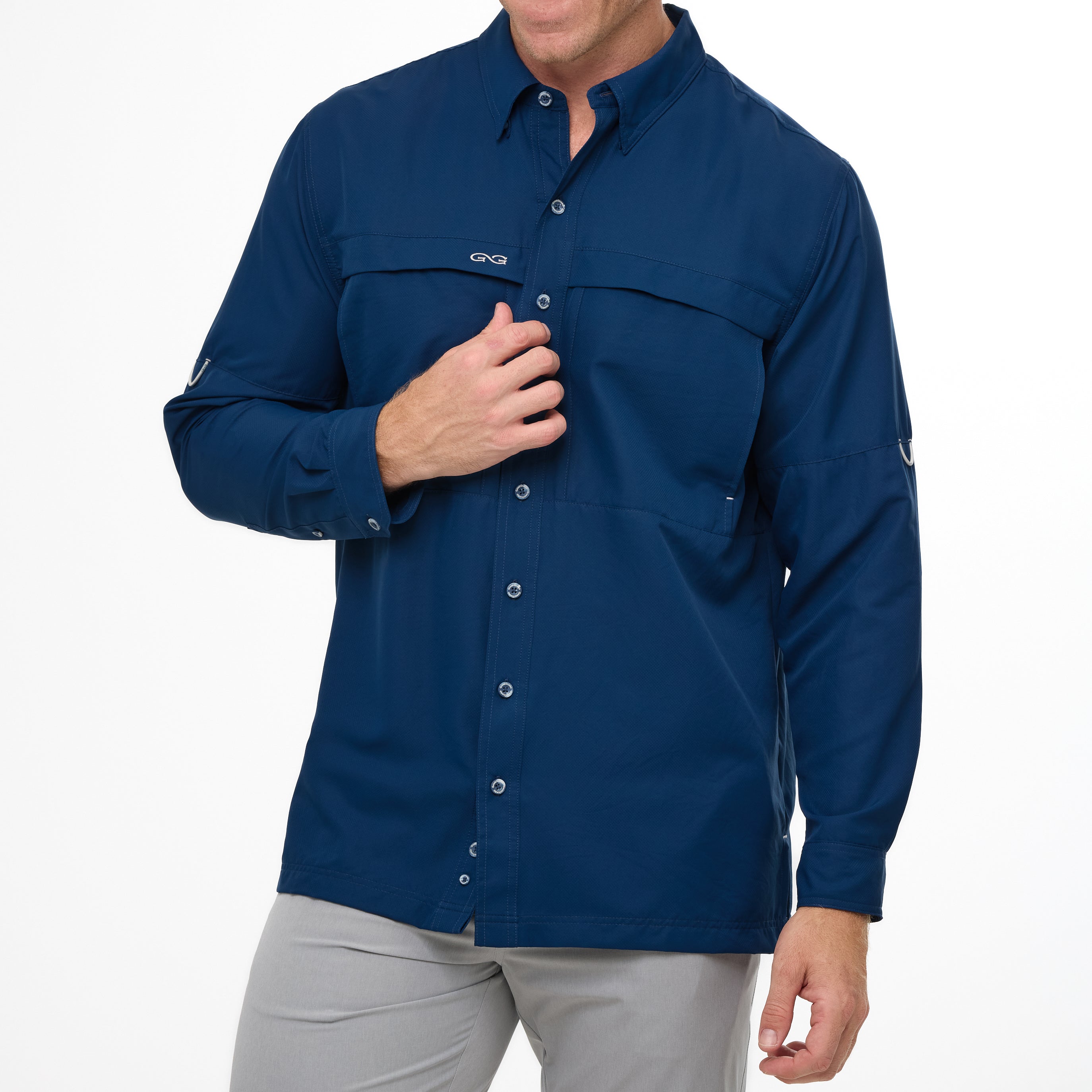 Man wearing a blue button-up shirt with a visible brand logo on a white background