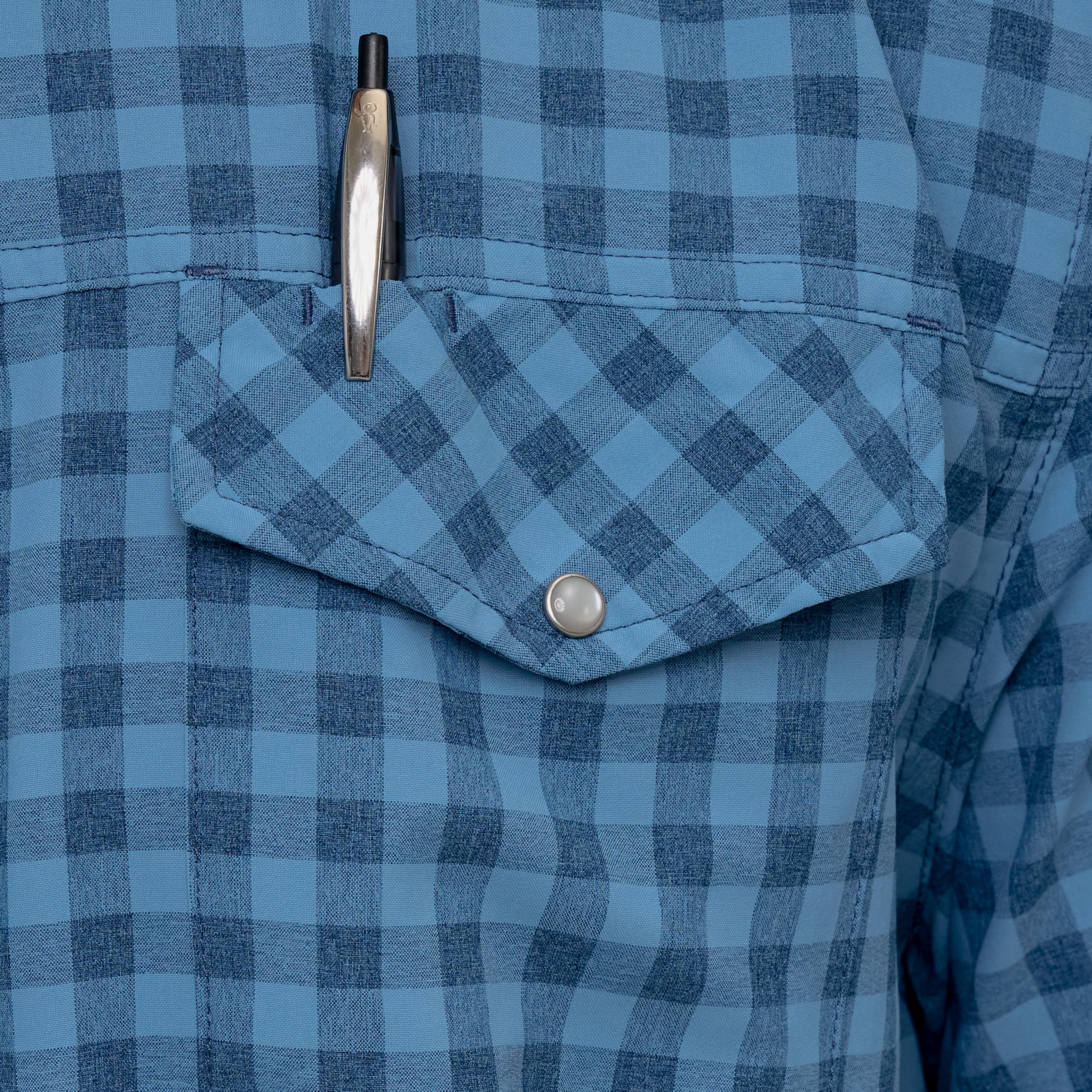 Close-up of a blue checkered shirt with a pen in the pocket