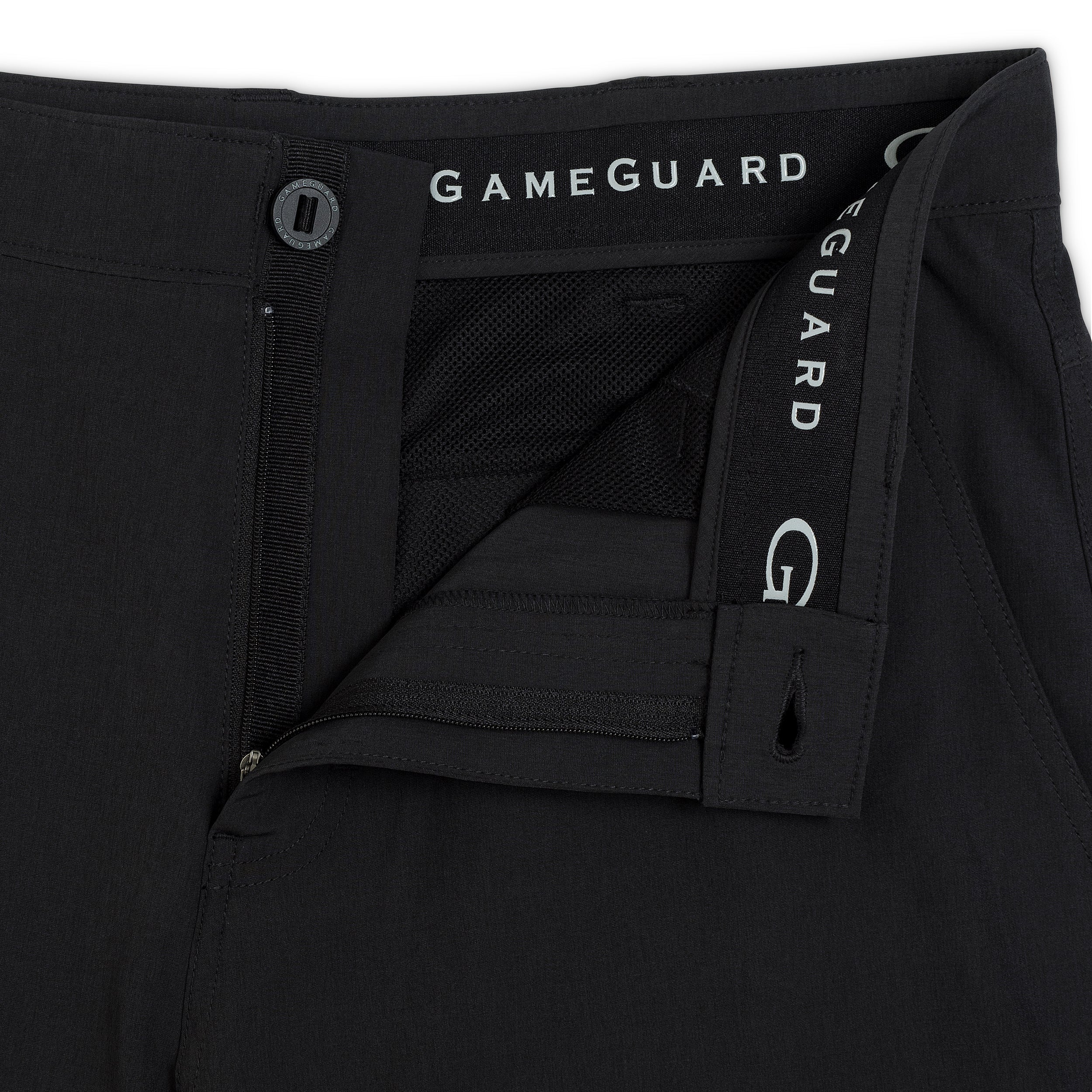 Close-up of black GameGuard athletic pants showing the waistband, button closure, and branded elastic side strap.