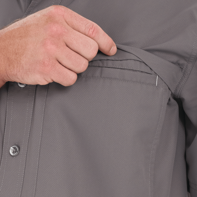 Close-up of a person adjusting the pocket of a gray jacket.