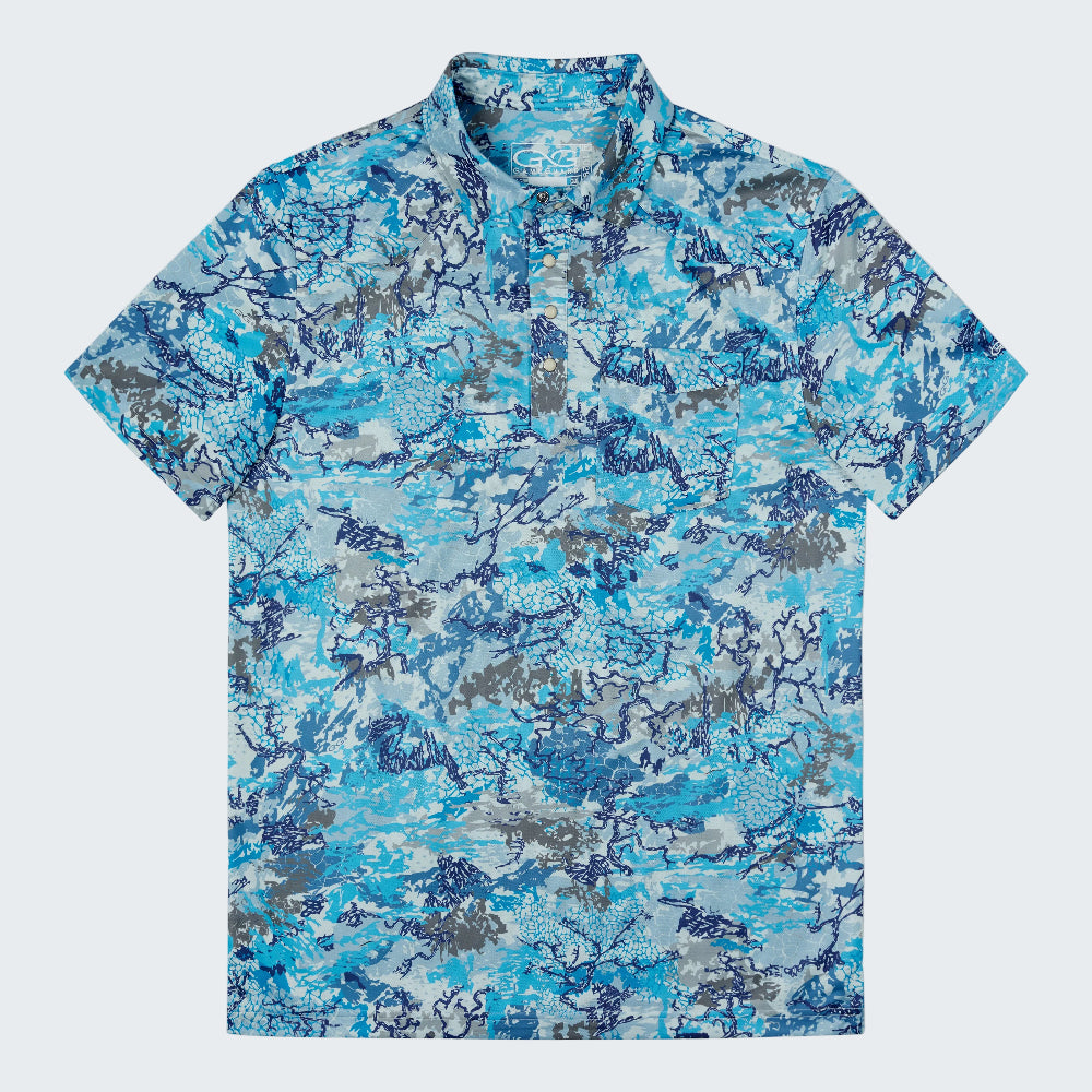 A short-sleeve collared polo shirt with an all-over abstract camouflage pattern in shades of blue, gray, and white, displayed flat against a solid white background.