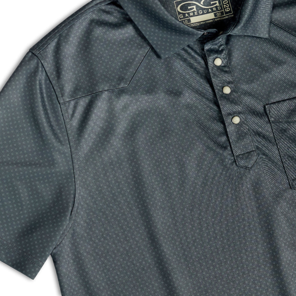 Close-up of a dark gray short-sleeve polo shirt with a subtle white micro-dot pattern, featuring a three-button placket and a chest pocket.