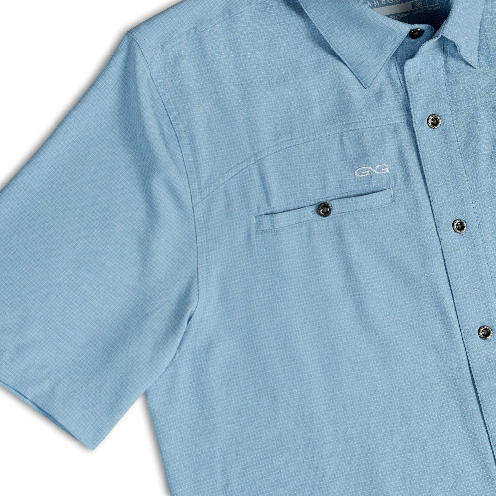 A light blue short-sleeve button-up shirt with a chest pocket and a small white embroidered logo on the left chest, shown on a white background.