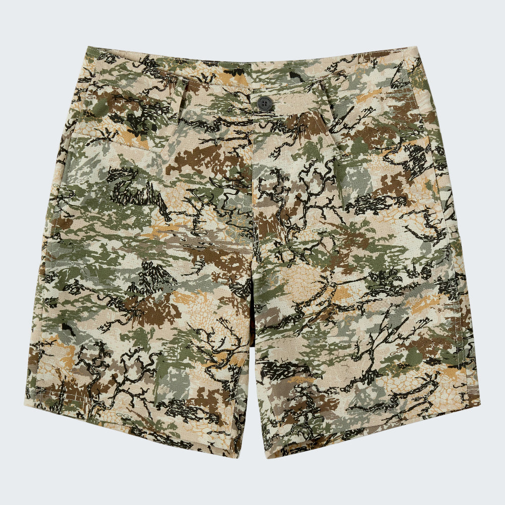 A pair of men's shorts featuring a digital camouflage pattern in beige, green, brown, and black, displayed flat against a solid white background.