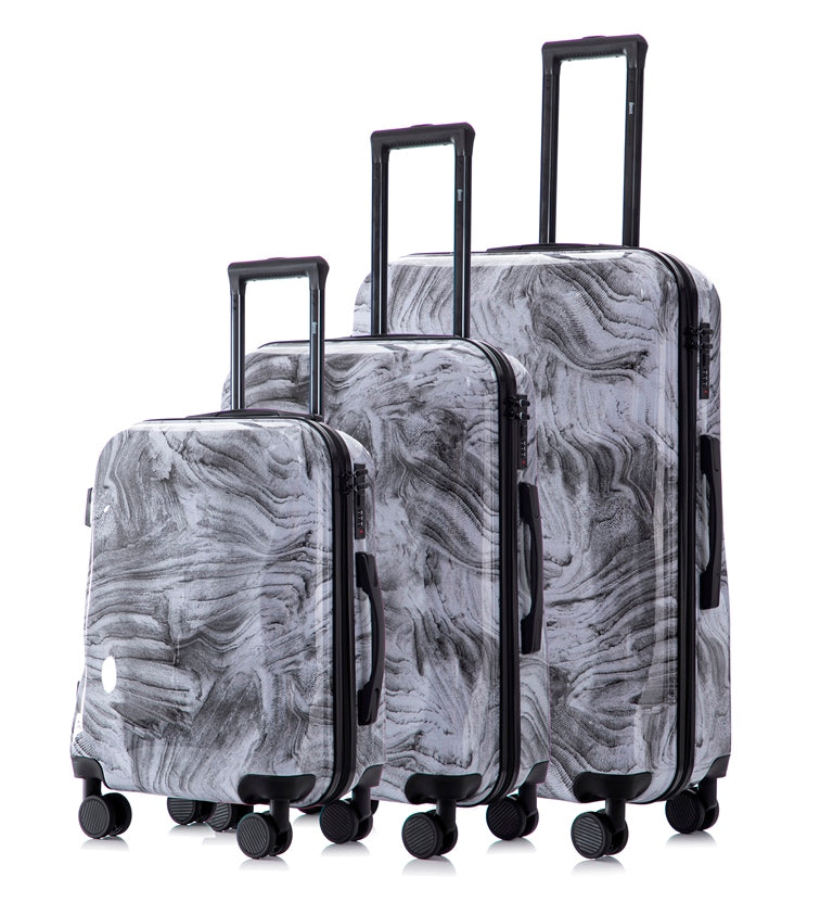 Set of three gray marbled suitcases with black handles and wheels on a white background