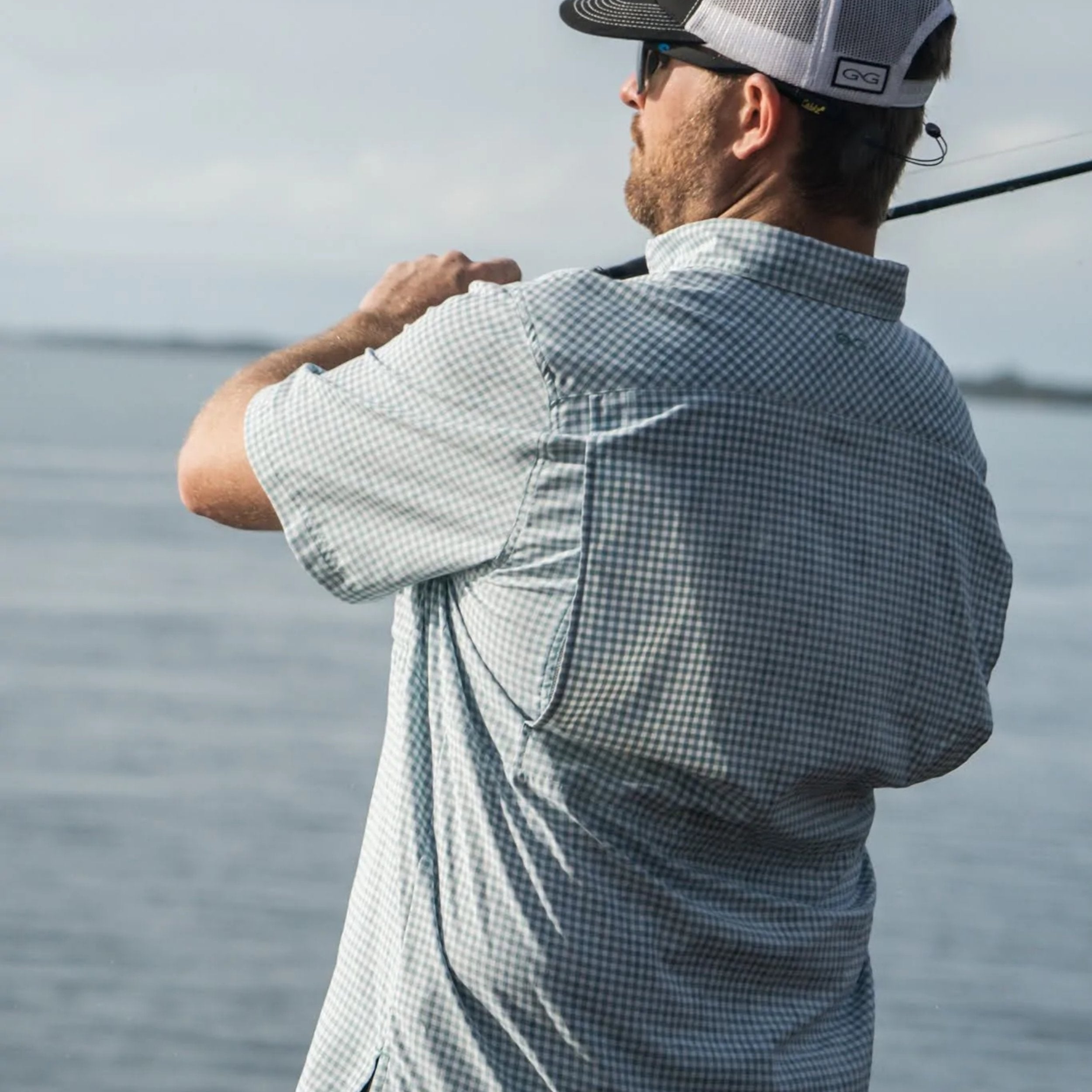 Man fishing on a boat with water in the background