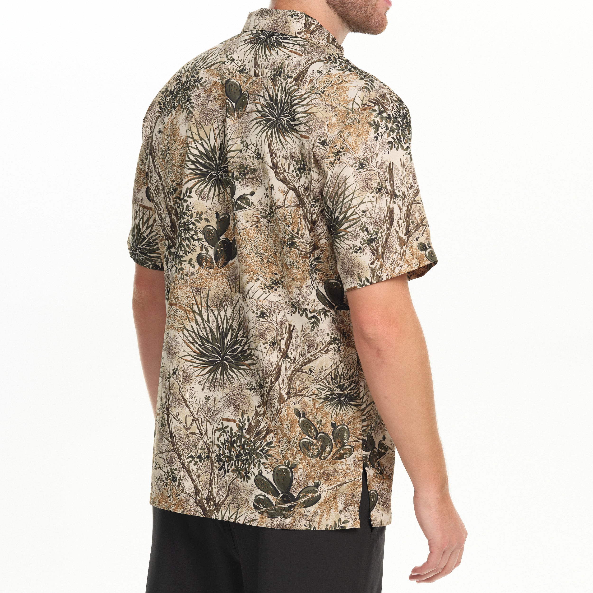 Man wearing a short-sleeve shirt with a nature-themed pattern on a white background