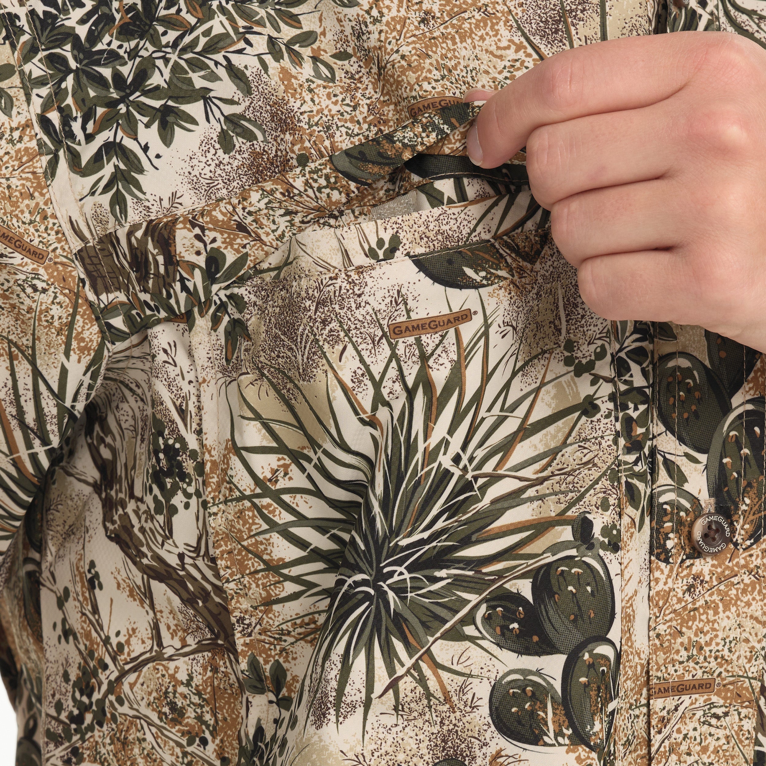 Close-up of a camouflage-patterned shirt with a hand adjusting the collar.