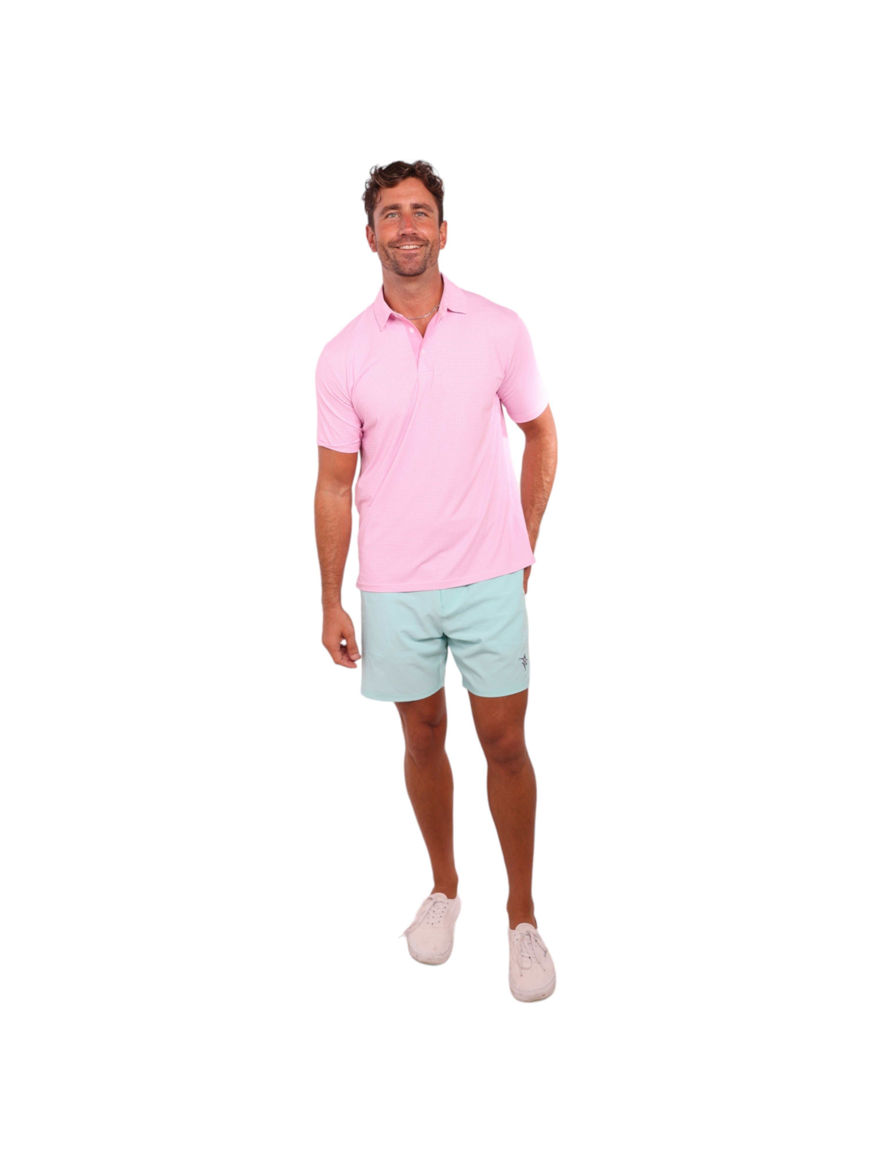 Man wearing a pink polo shirt and light blue shorts on a white background