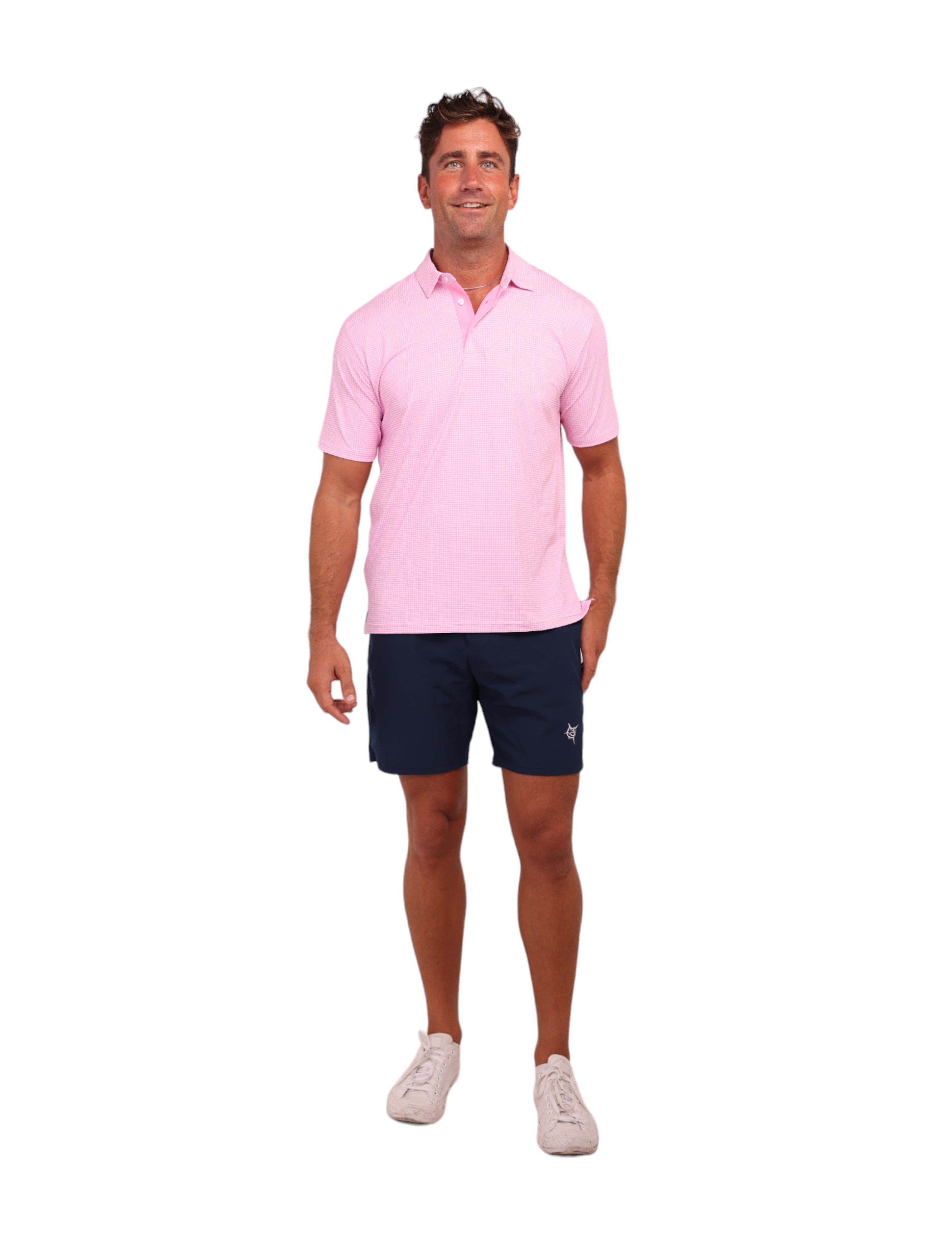 Man wearing a pink polo shirt and navy shorts on a white background