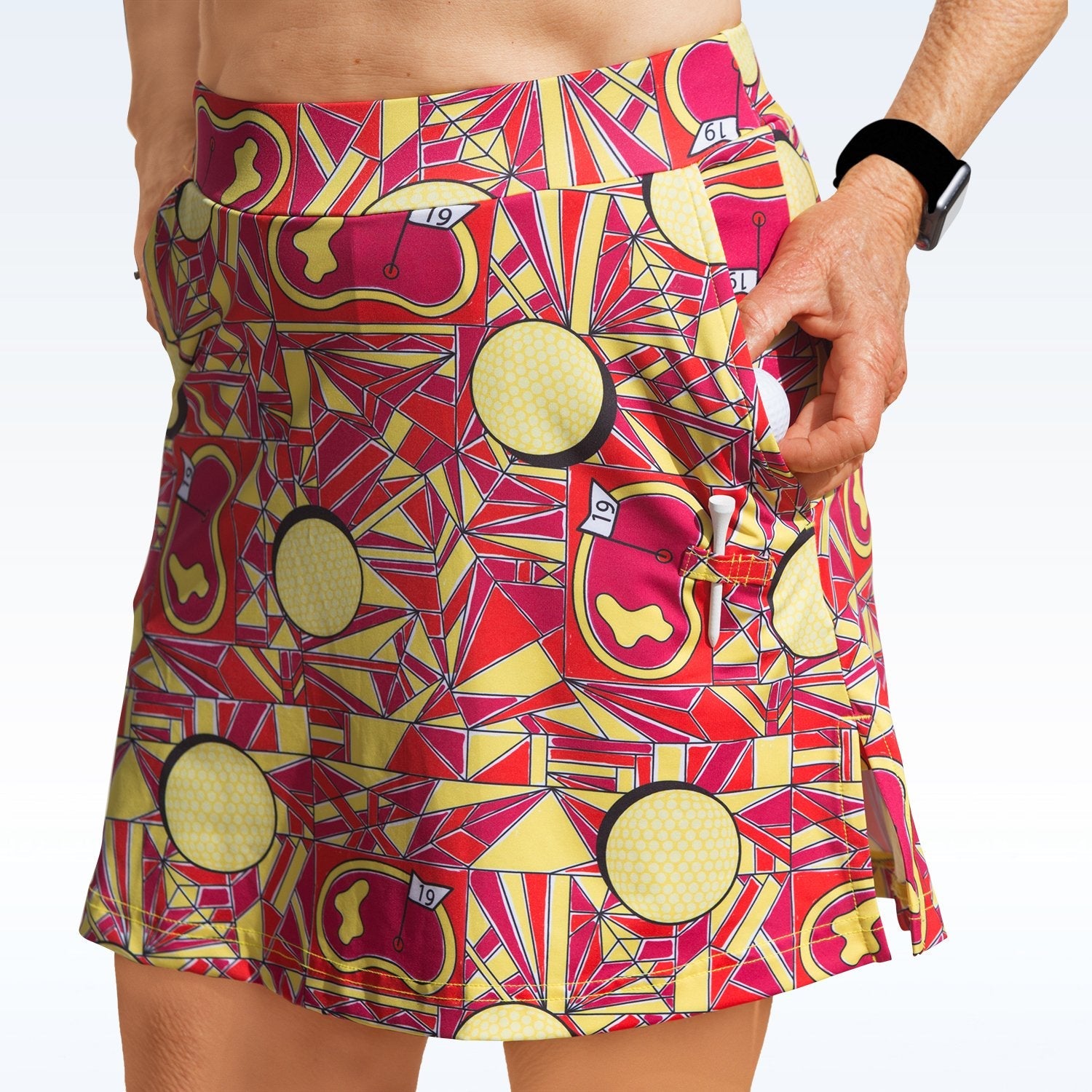 Person wearing a colorful patterned skirt with geometric design on a white background