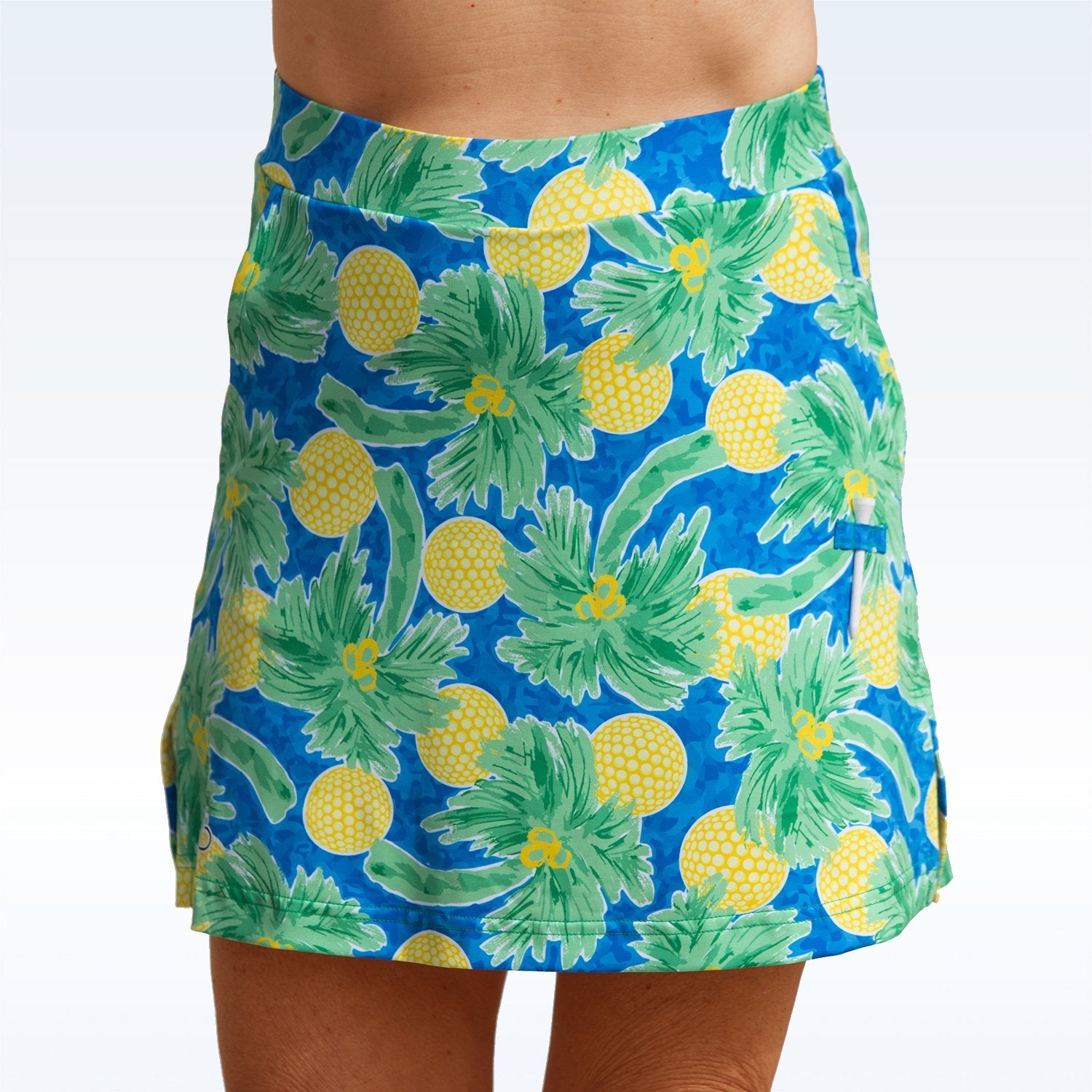 Blue skirt with pineapple pattern worn by a person on a white background