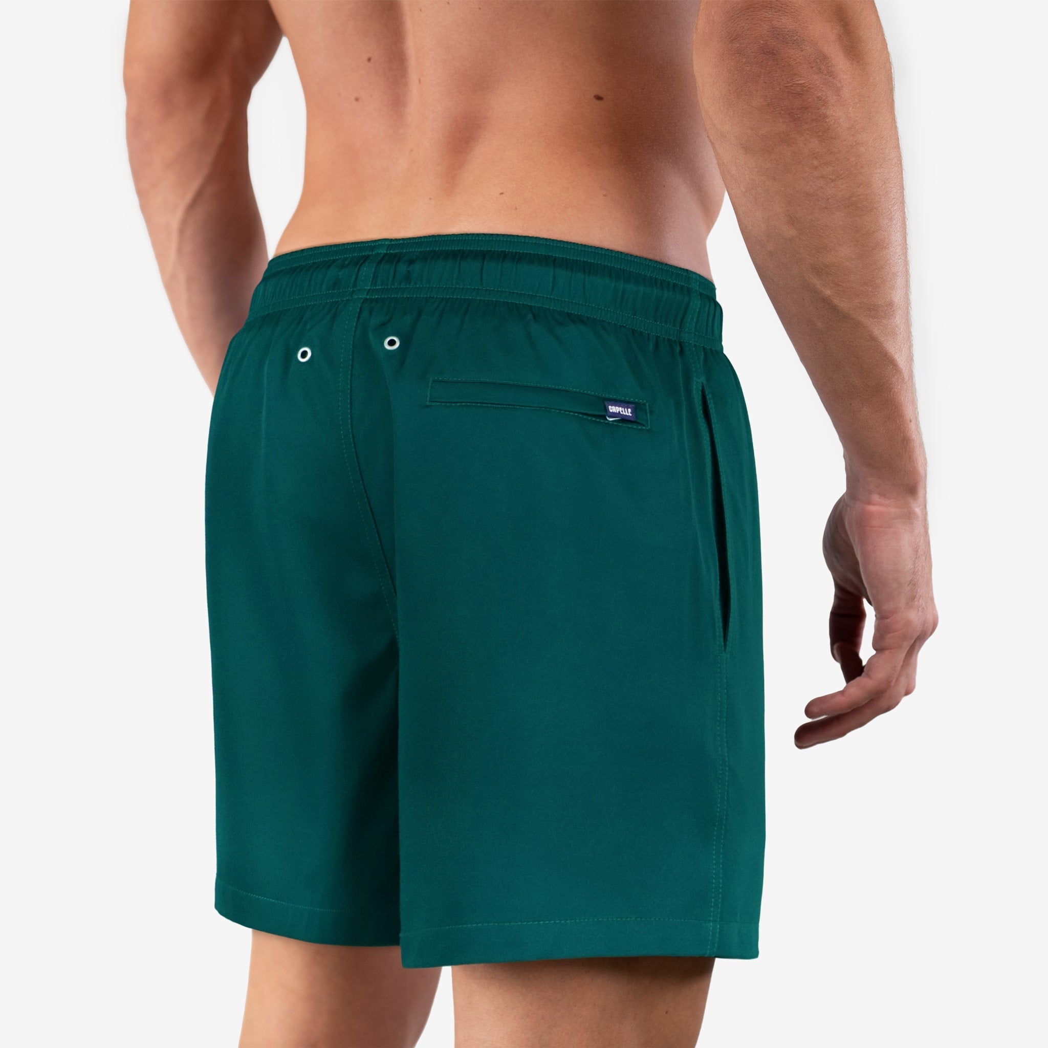 Green swim shorts worn by a person on a white background