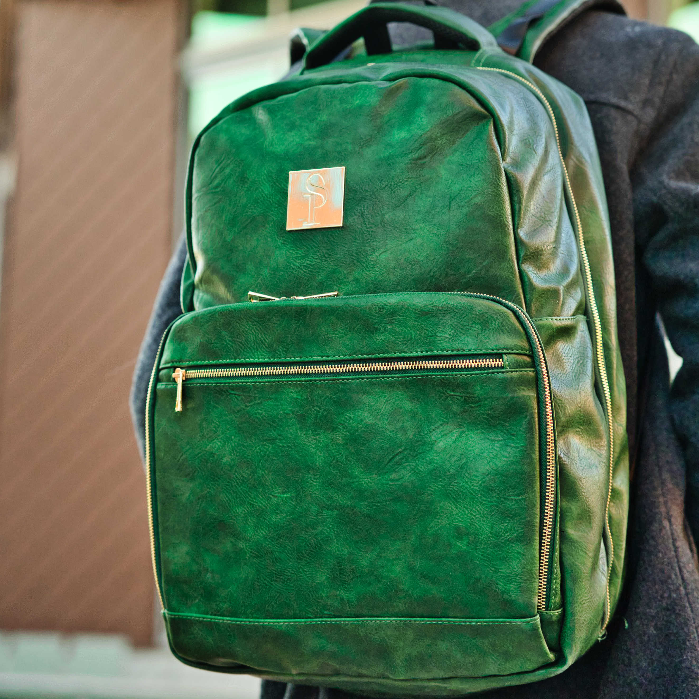 Green backpack with a visible brand logo on a blurred background