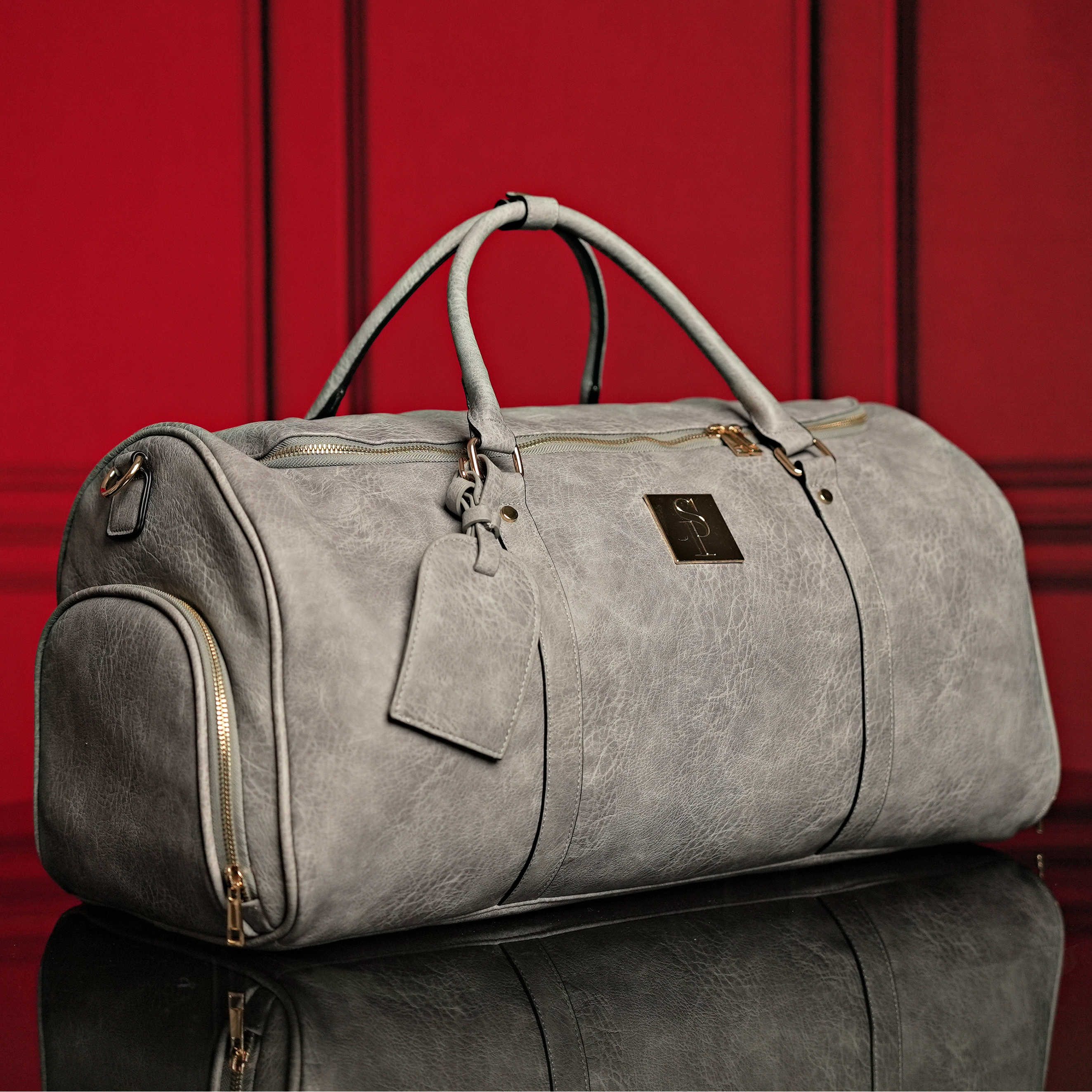 Gray duffel bag with a tag on a red background