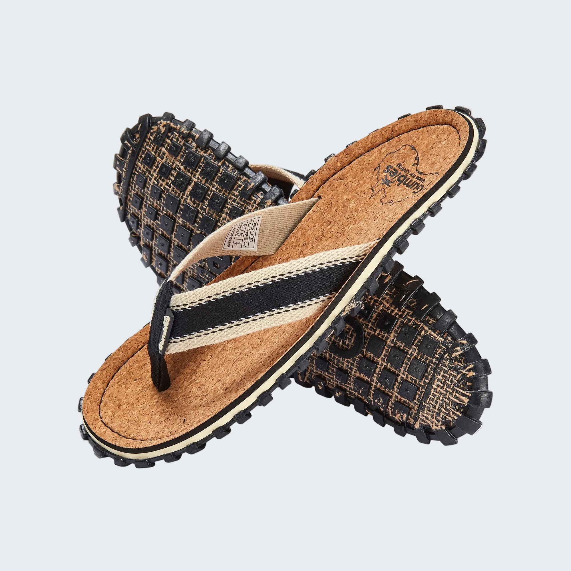 Pair of sandals with cork sole and woven strap on a white background