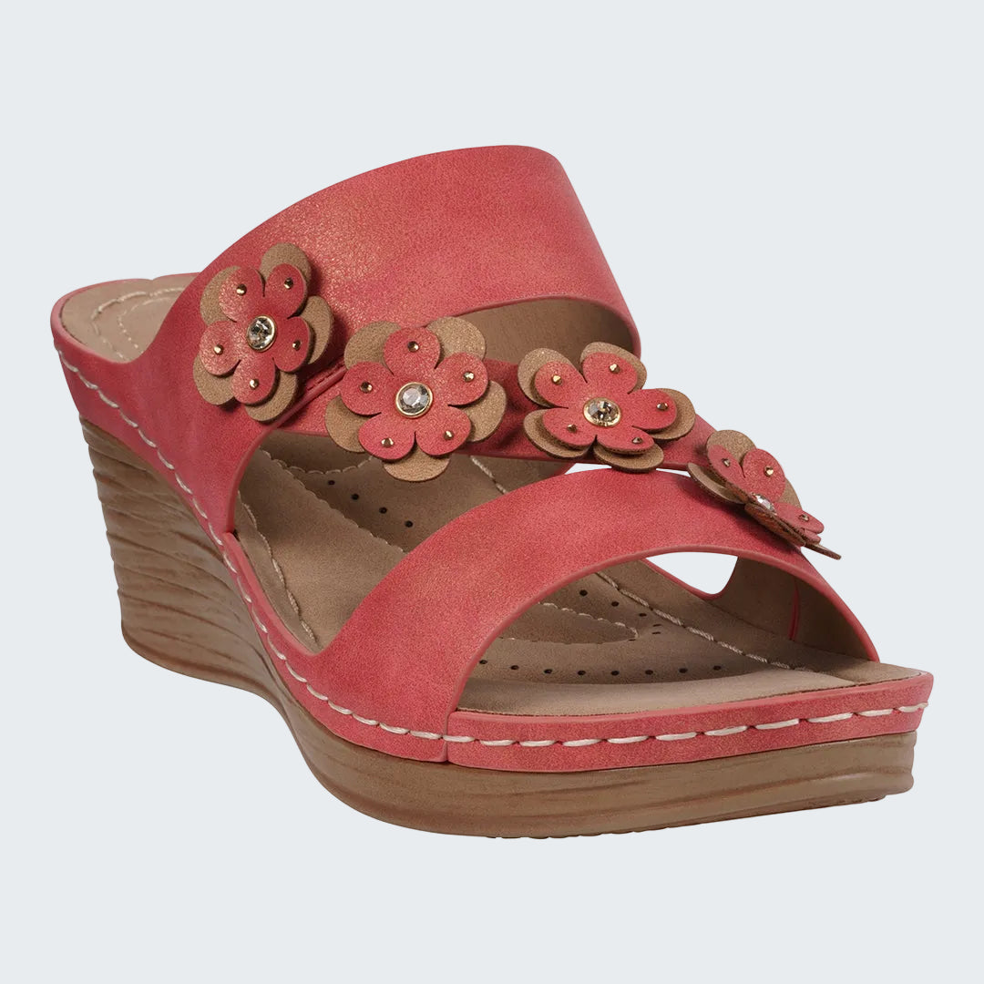 Red wedge sandal with floral decorations on a white background