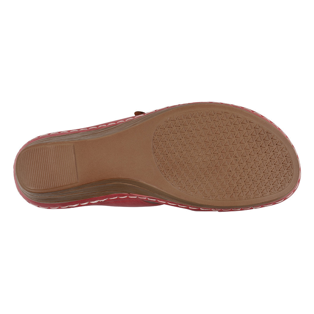 Close-up of a sandal sole with brown leather and pink fabric on a white background