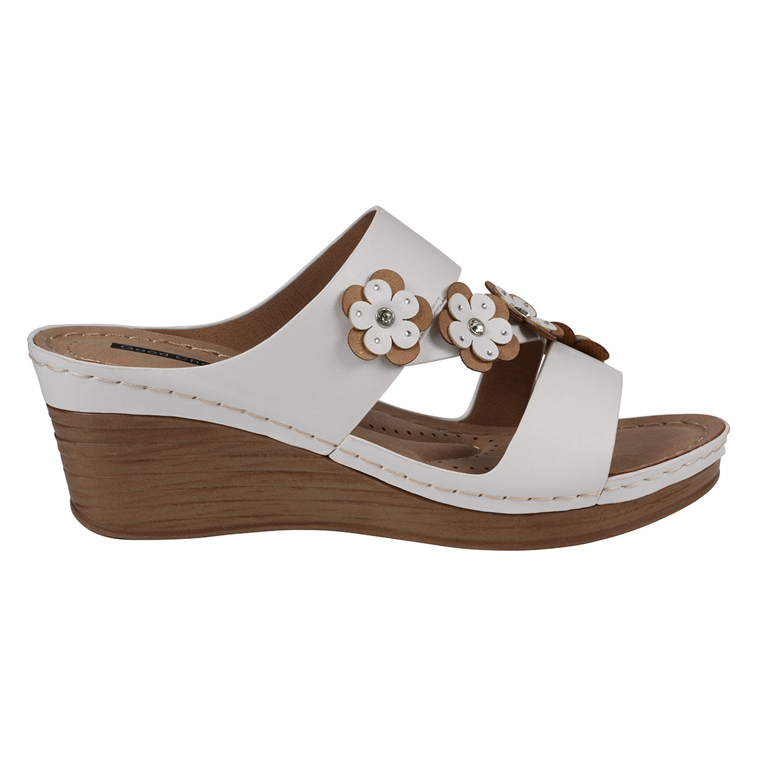 White wedge sandal with brown accents and floral decorations on a white background
