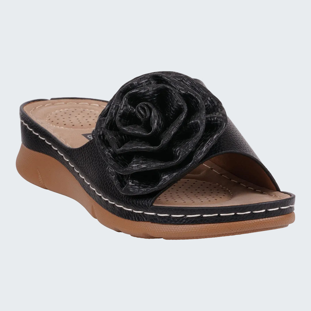 Black sandal with a flower design on a white background