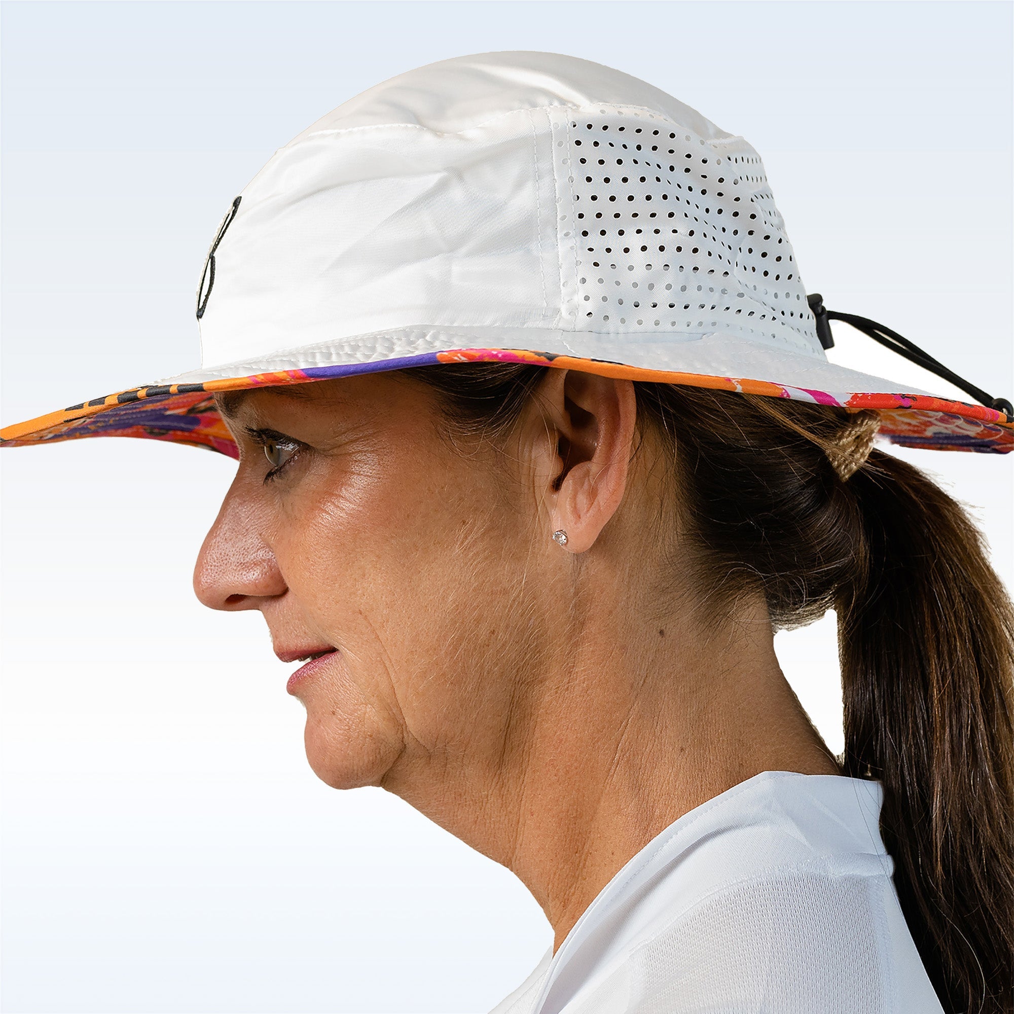 Woman wearing a white sun hat with colorful brim against a clear sky