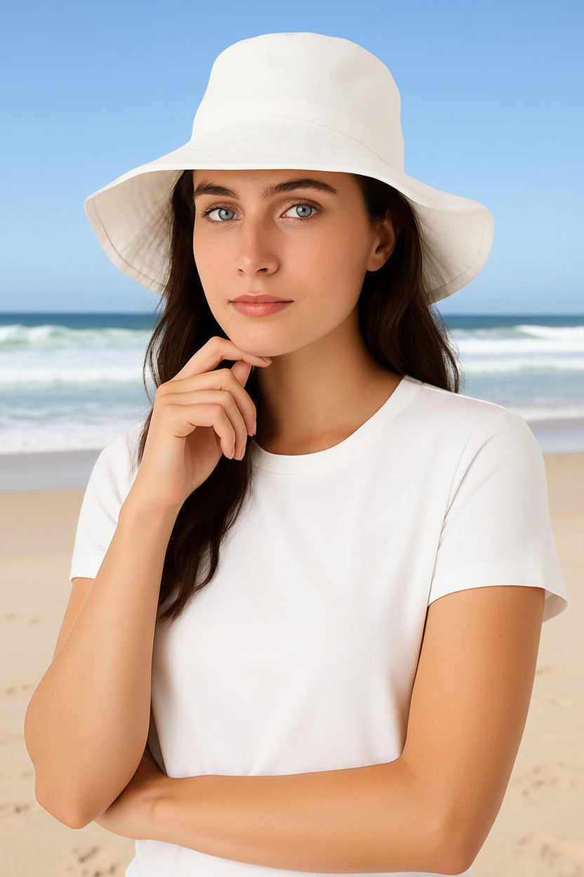 Woman wearing a white hat and white shirt against a light gray background