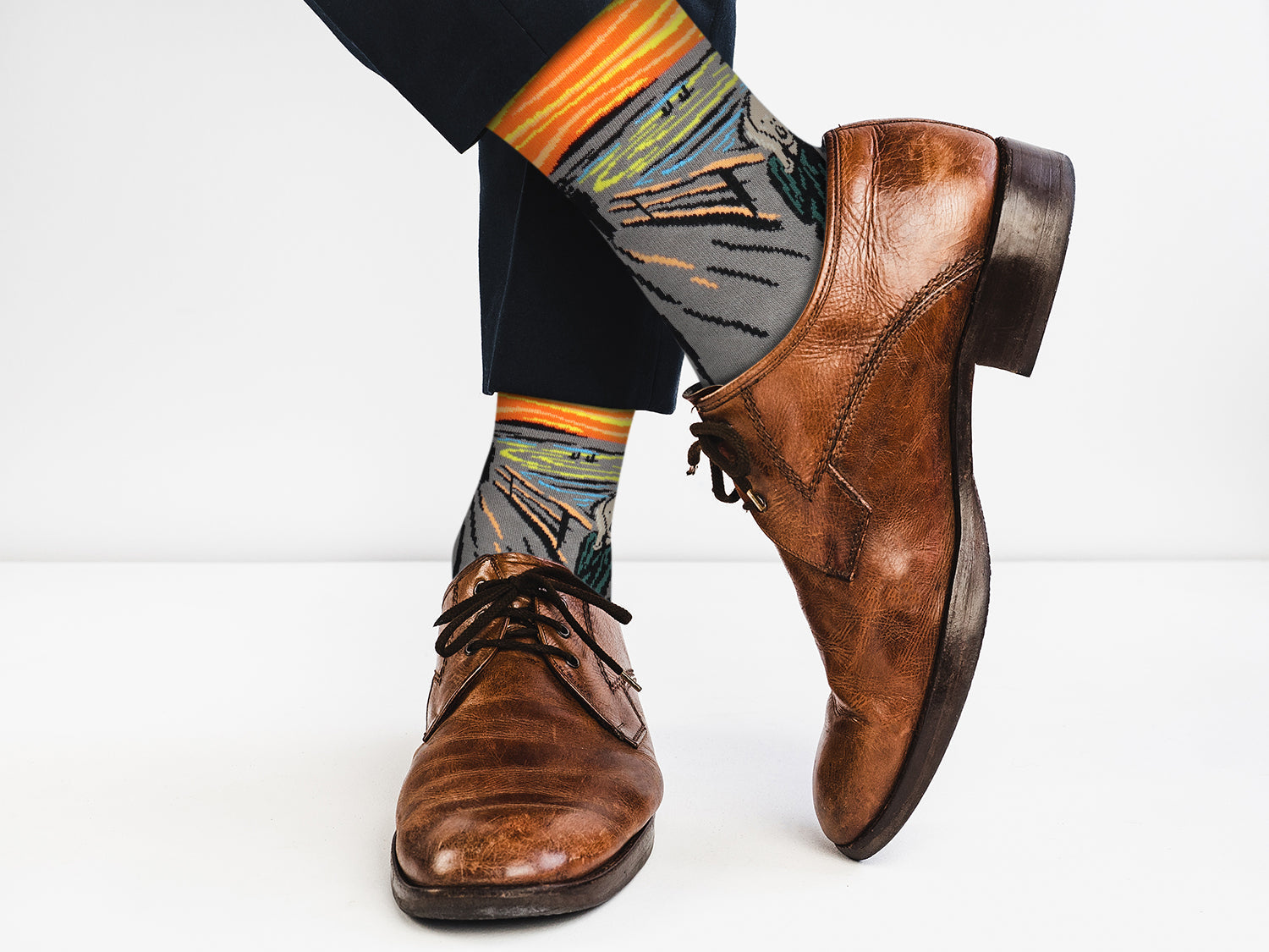 Brown leather shoes with patterned socks on a white background