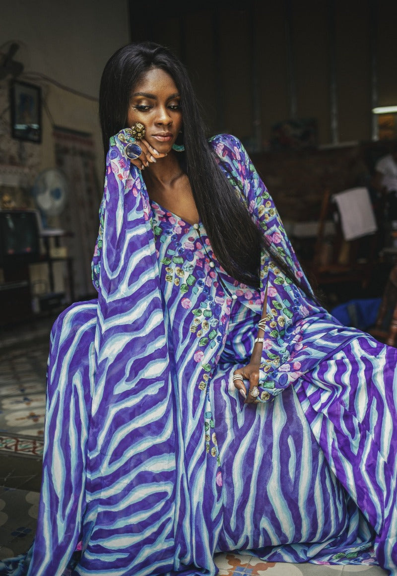 Woman wearing a colorful dress with a zebra pattern in an indoor setting