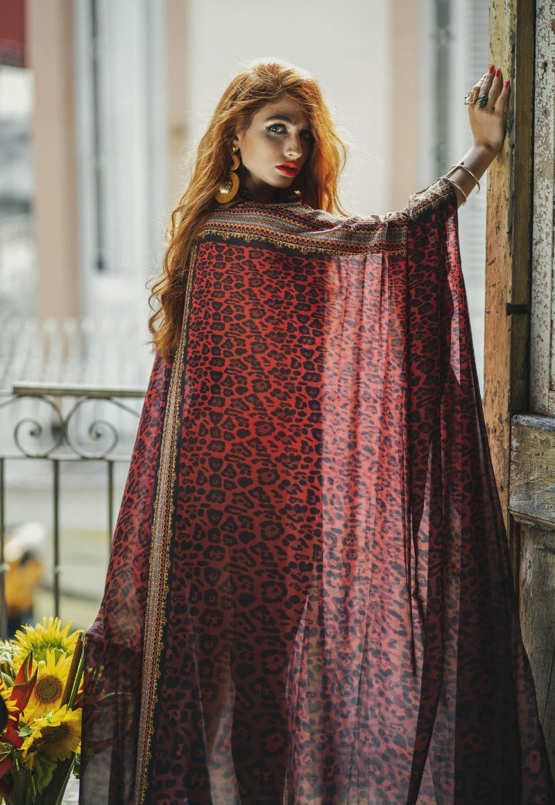 Woman wearing a red and black patterned shawl outdoors
