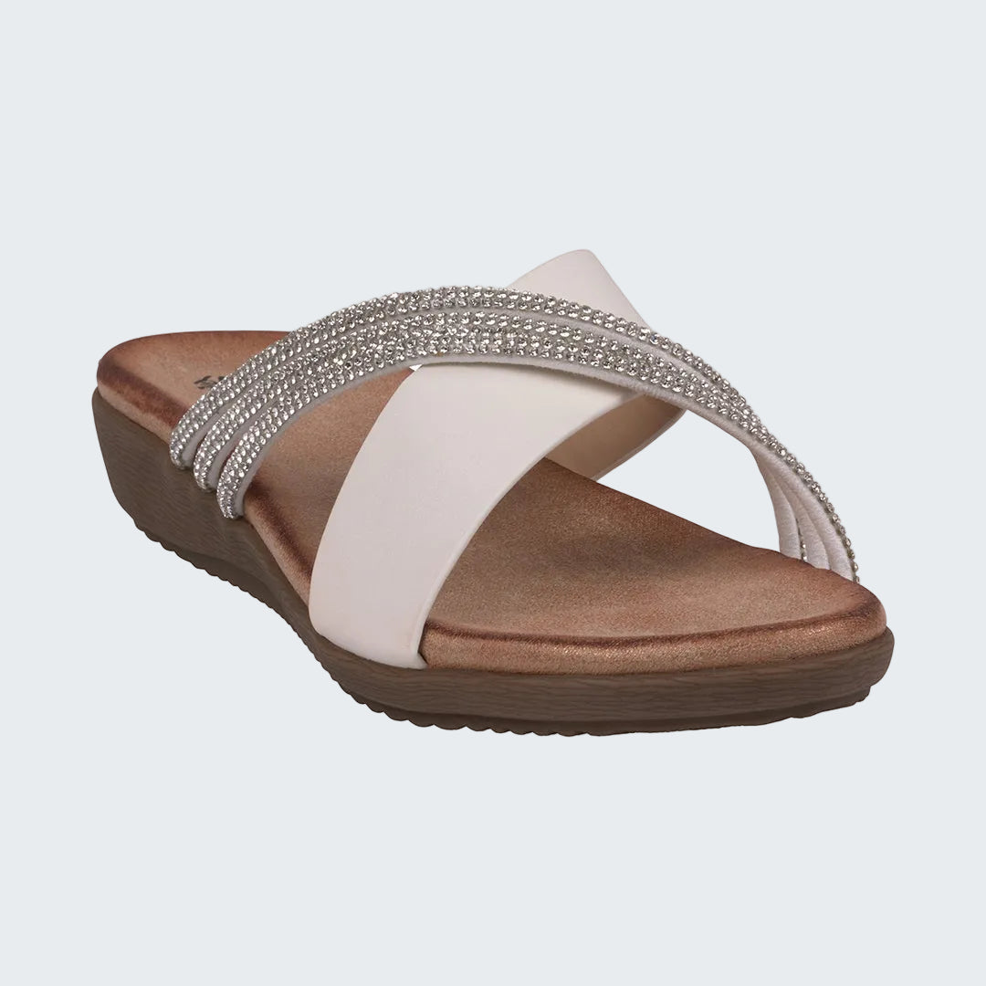 Womens sandal with brown sole, white strap, and silver embellishments on a white background