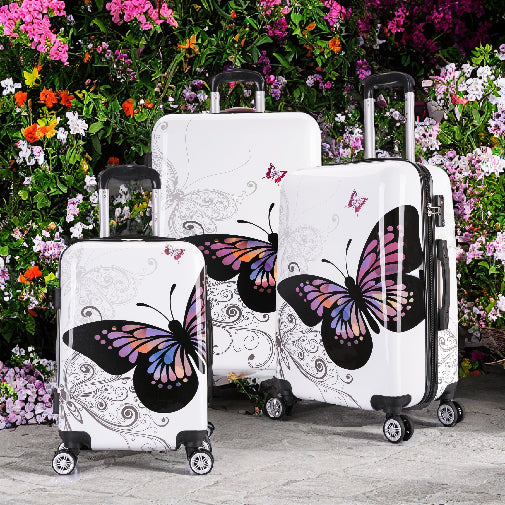 Set of three suitcases with butterfly designs against a floral background