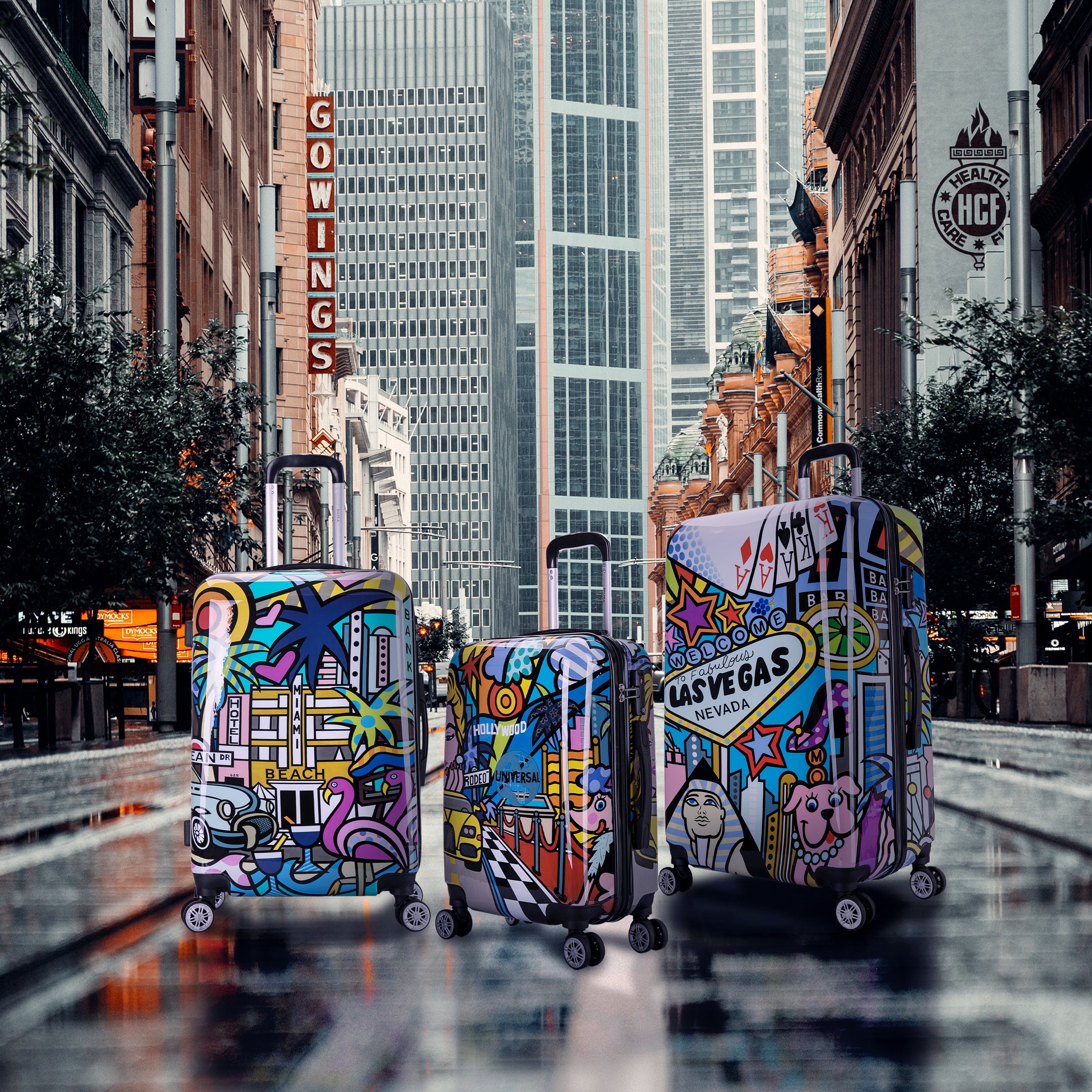 Colorful suitcases with city-themed designs on a city street.